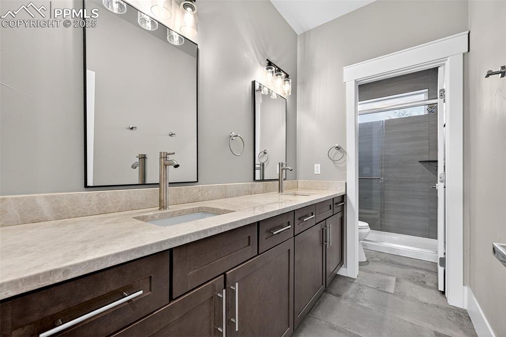 485 Cardiff Circle Colorado Springs, CO 80906 - Photo 28 of 50 a bathroom with a granite countertop sink and a mirror