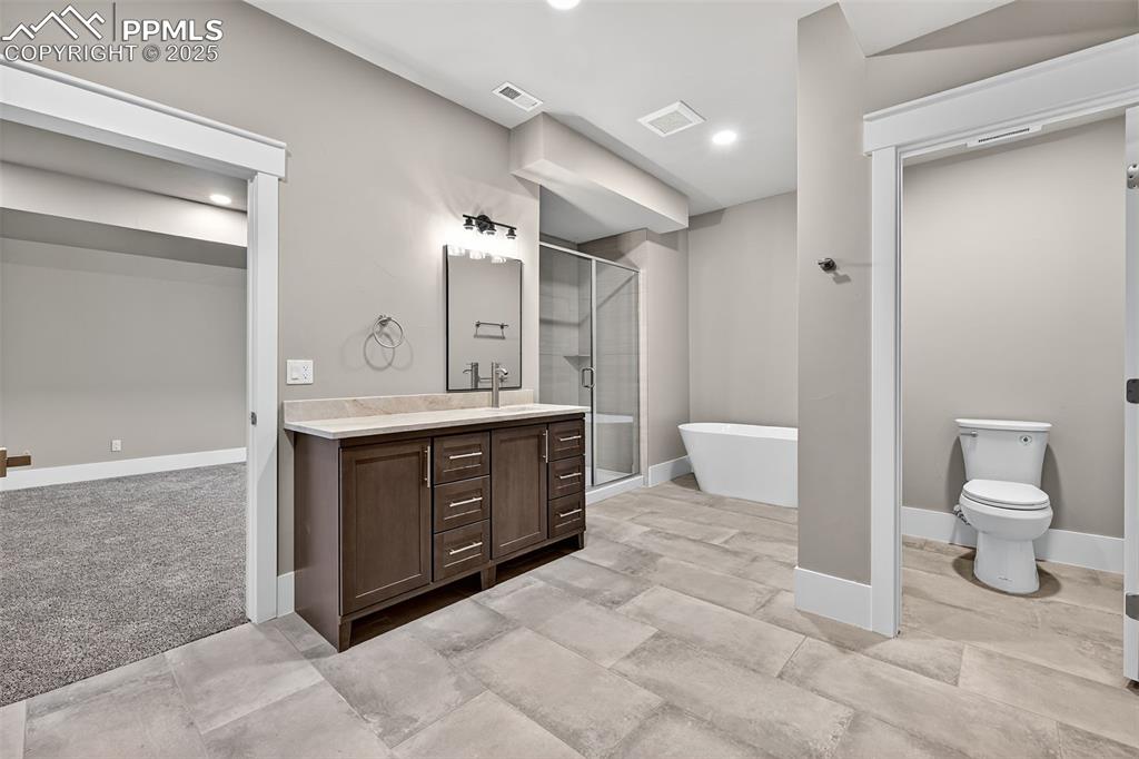 485 Cardiff Circle Colorado Springs, CO 80906 - Photo 44 of 50 a spacious bathroom with a toilet sink and mirror