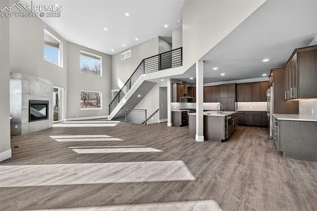 a kitchen with granite countertop a sink a stove a counter space and cabinets