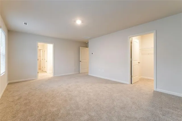 an empty room with windows and closet