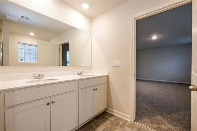 a bathroom with a double vanity sink and a mirror