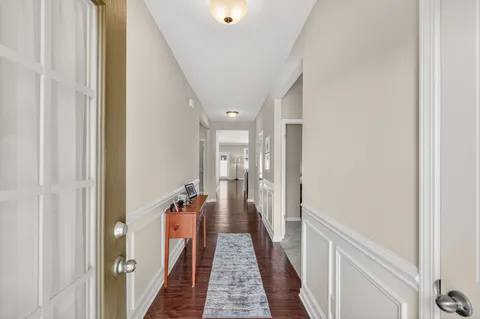a view of a hallway with wooden floor and staircase