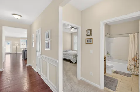 a view of a hallway with wooden floor and bedroom