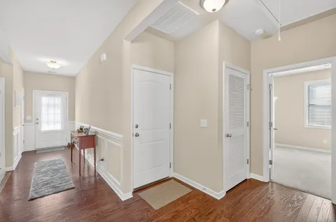 a view of a hallway with wooden floor and closet