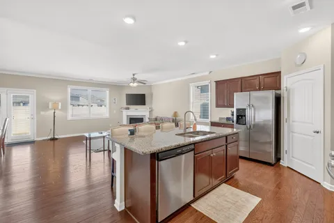 a kitchen with center island wooden floor and stainless steel appliances