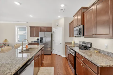 a kitchen with granite countertop a sink counter top space appliances and cabinets