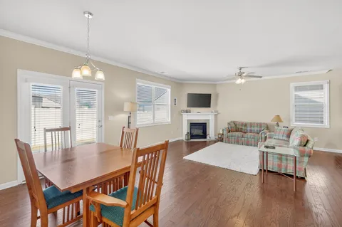 a dining room with furniture a chandelier and wooden floor