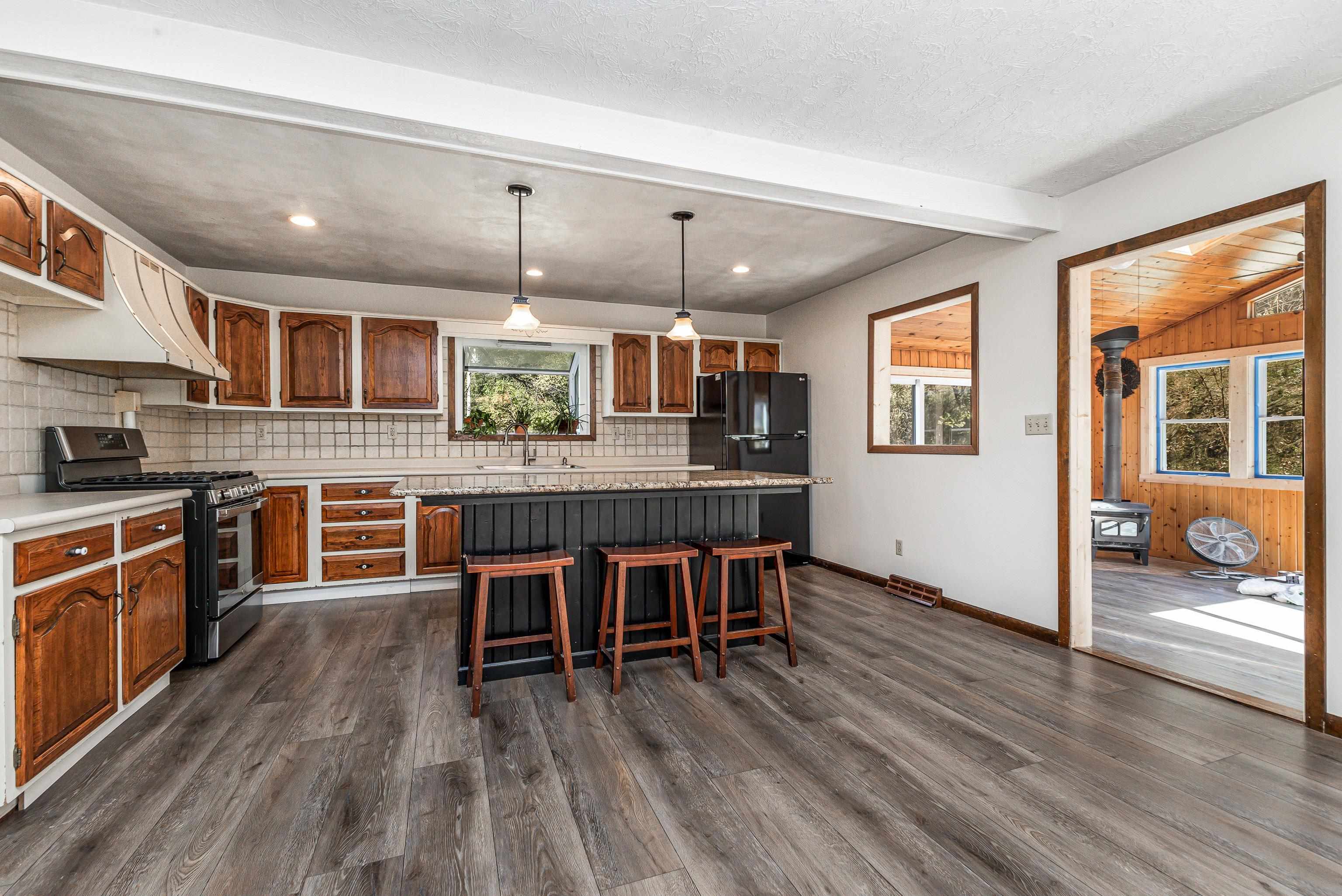 151 North Blackjack Road Galena, IL 61036 - Photo 12 of 65 a kitchen with stainless steel appliances granite countertop a stove top oven a sink dishwasher a dining table and chairs with wooden floor