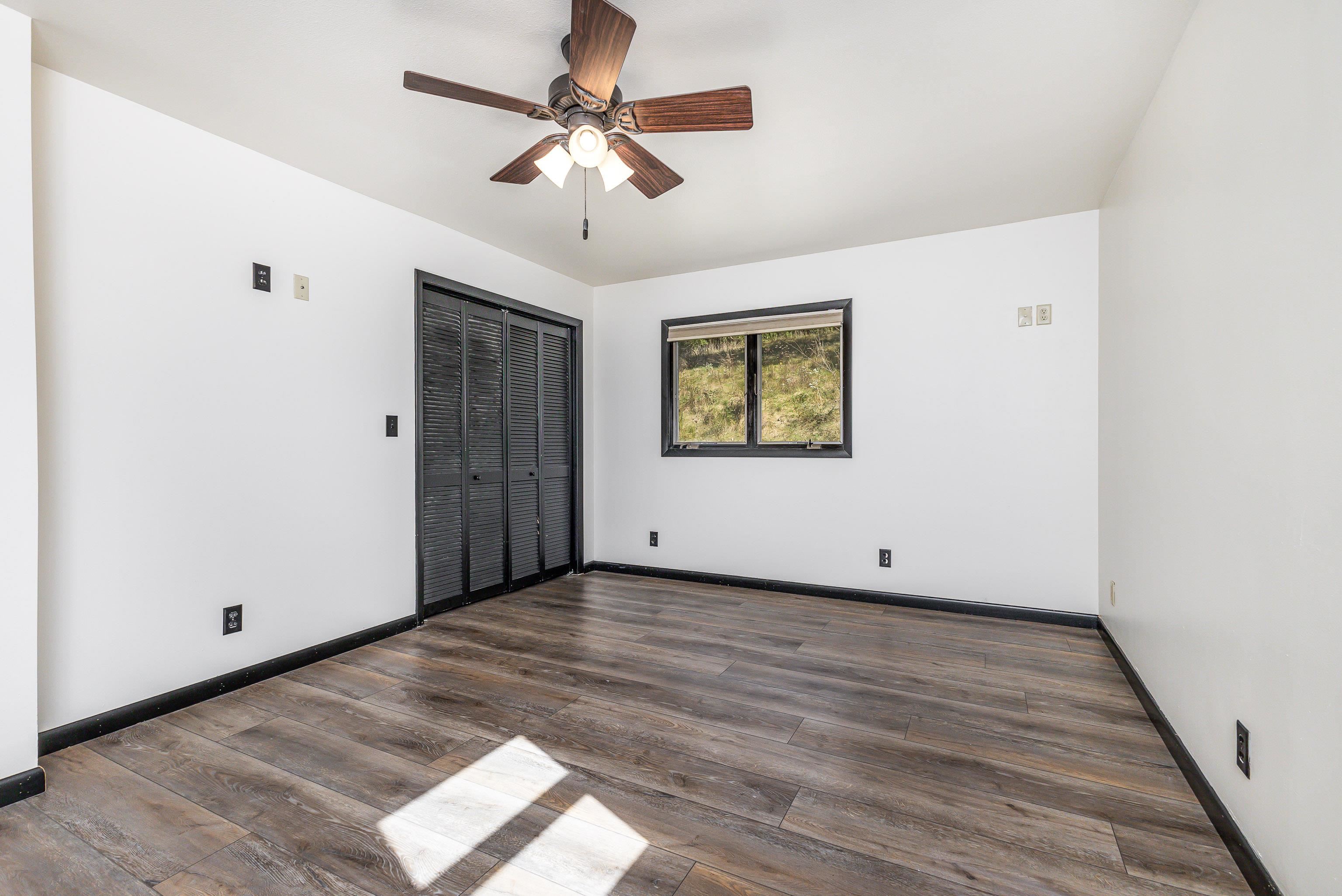 151 North Blackjack Road Galena, IL 61036 - Photo 29 of 65 an empty room with wooden floor chandelier fan and windows