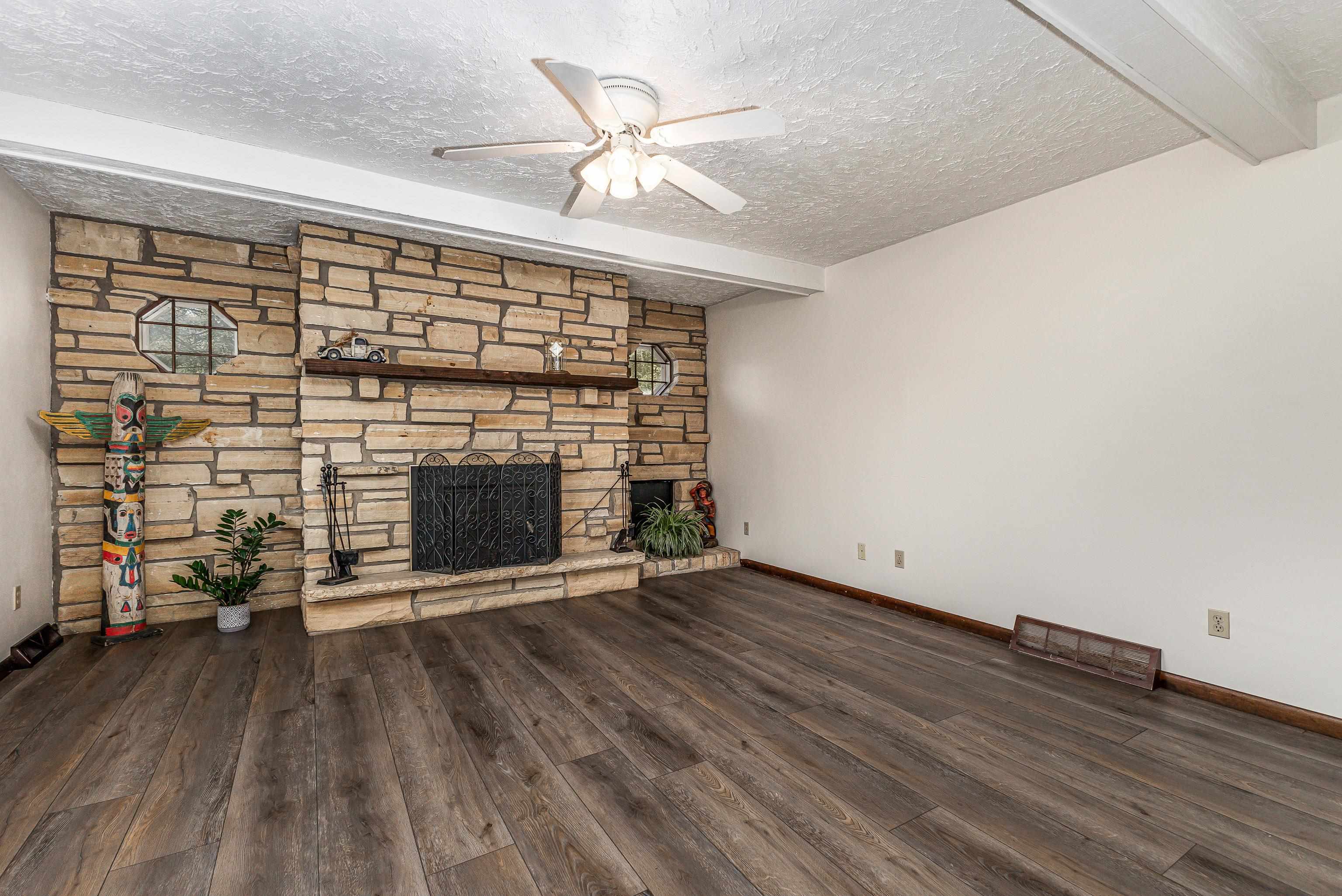 151 North Blackjack Road Galena, IL 61036 - Photo 8 of 65 an empty room with wooden floor a fireplace and windows