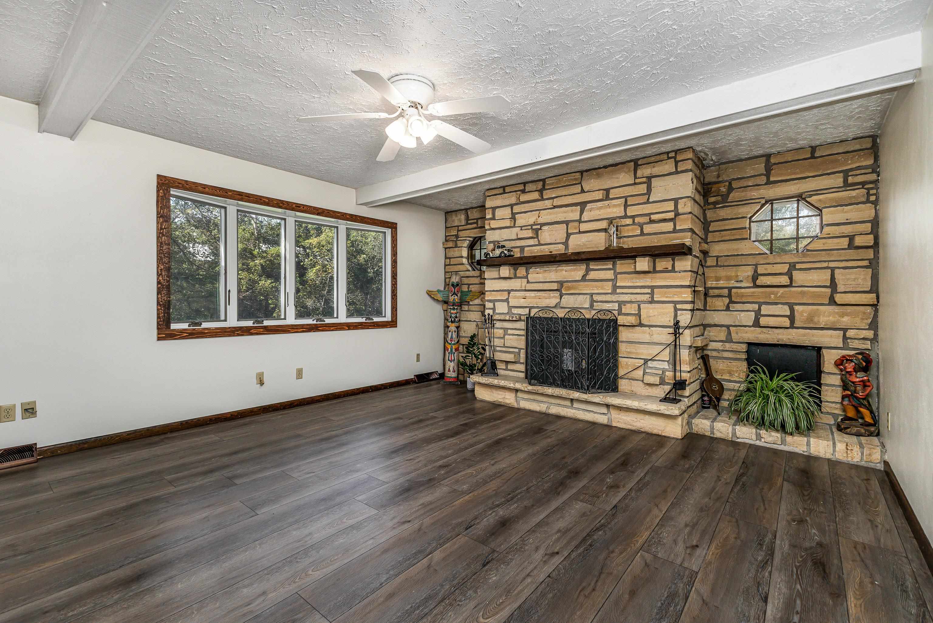 151 North Blackjack Road Galena, IL 61036 - Photo 9 of 65 a view of an empty room with wooden floor fireplace and a window