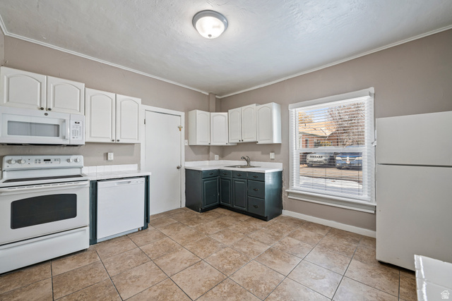 75 600 West Provo, UT 84601 - Photo 5 of 26 Kitchen featuring white upper cabinetry, contrasting dark lower cabinetry, and a white refrigerator