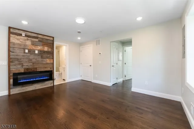 an empty room with wooden floor and window