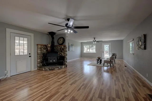 a dining room with wooden floor a chandelier a wooden table and chairs
