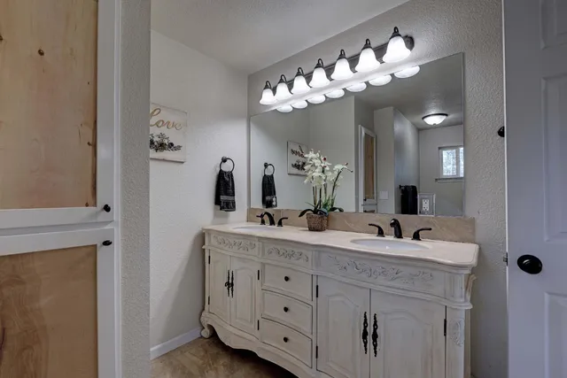 a bathroom with a sink vanity granite tub and shower