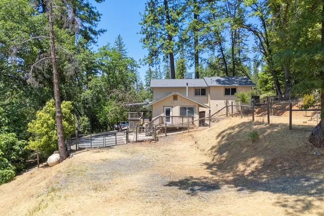 a view of a house with a tree next to a yard