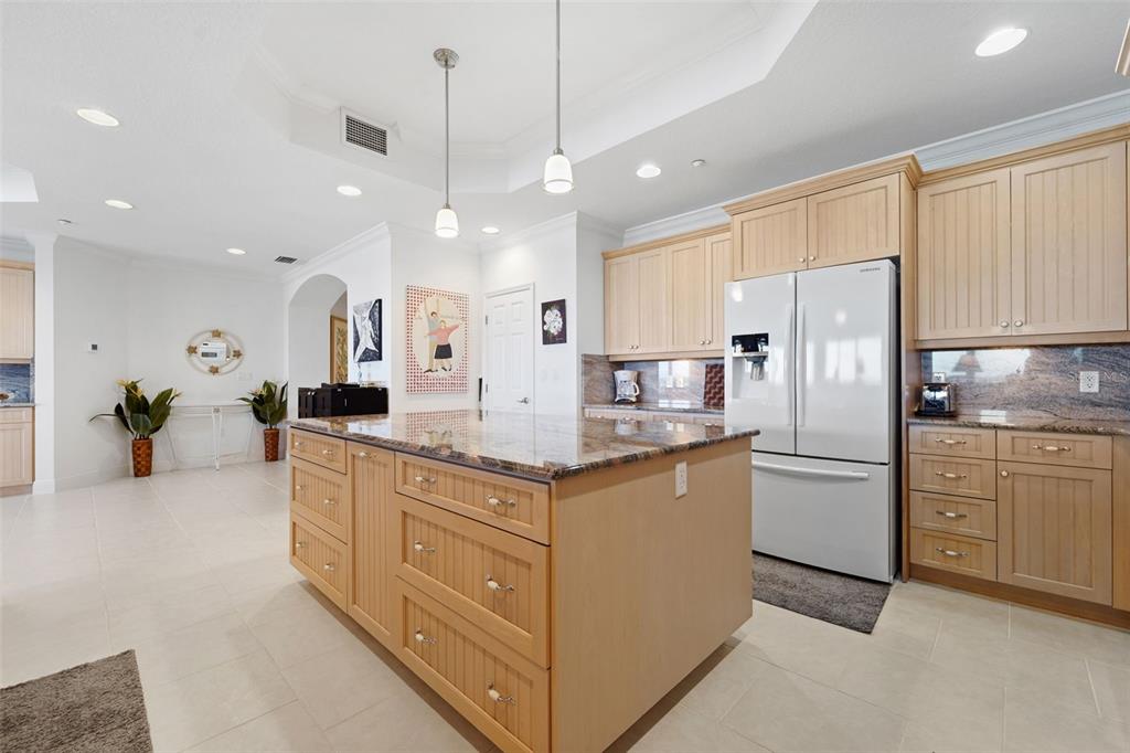 17735 Gulf Boulevard, Unit 702 Redington Shores, FL 33708 - Photo 11 of 60 a kitchen with stainless steel appliances granite countertop a refrigerator a sink and white cabinets