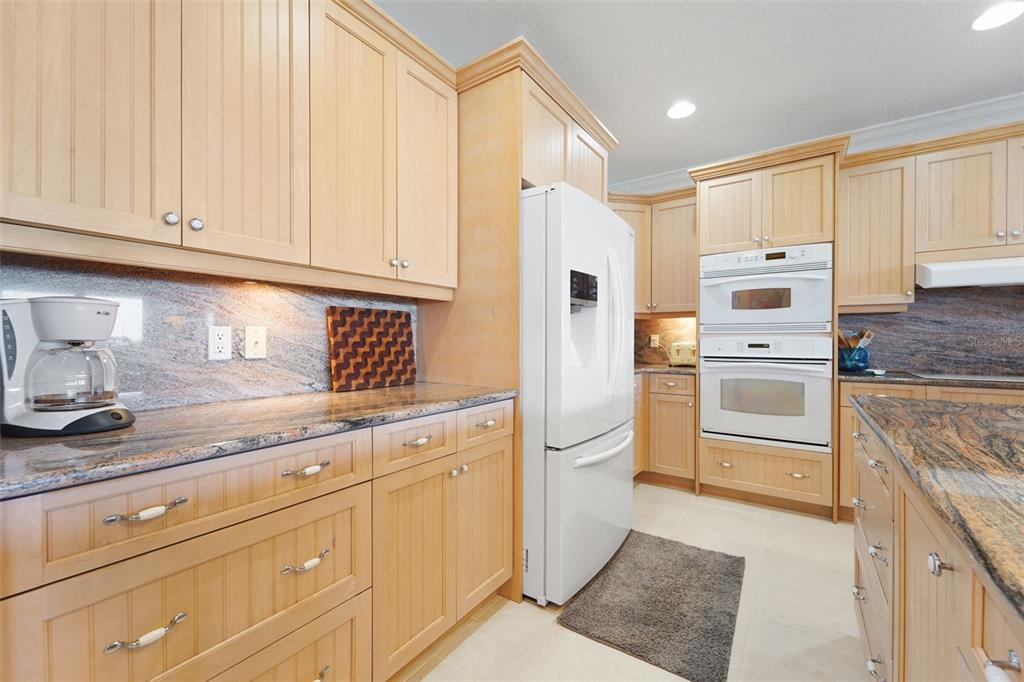 17735 Gulf Boulevard, Unit 702 Redington Shores, FL 33708 - Photo 12 of 60 a kitchen with granite countertop white cabinets and stainless steel appliances