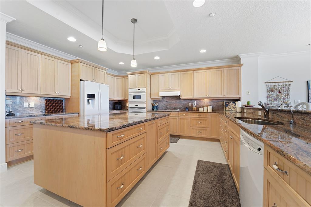 17735 Gulf Boulevard, Unit 702 Redington Shores, FL 33708 - Photo 14 of 60 a large kitchen with stainless steel appliances kitchen island granite countertop a sink and cabinets