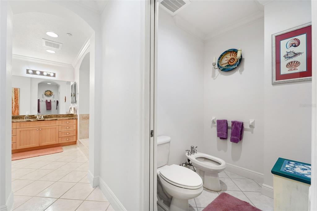 17735 Gulf Boulevard, Unit 702 Redington Shores, FL 33708 - Photo 23 of 60 a bathroom with a toilet a sink and a mirror