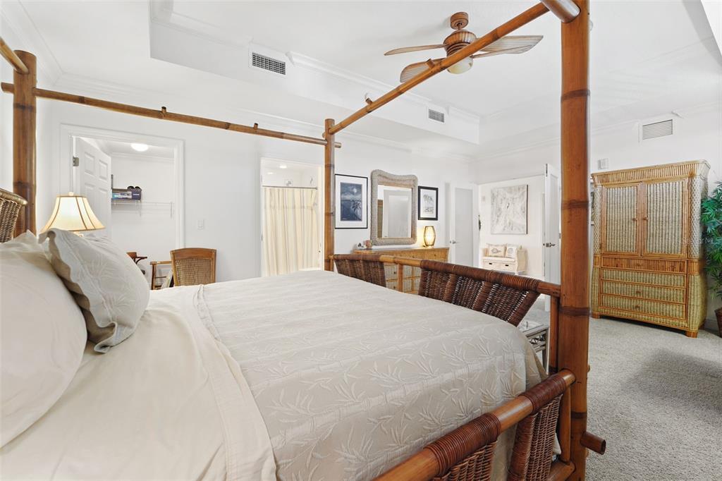 17735 Gulf Boulevard, Unit 702 Redington Shores, FL 33708 - Photo 28 of 60 a bedroom with a bed a mirror and a flat tv screen on the dresser