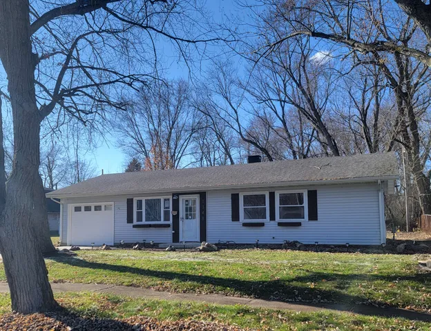 a view of a yard in front of a house with large tree