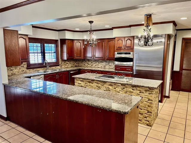 a kitchen with stainless steel appliances granite countertop a sink stove and refrigerator