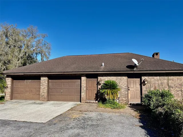 a backyard of a house with table and chairs under an umbrella