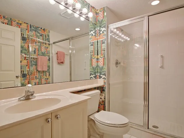 a bathroom with a sink vanity mirror and toilet