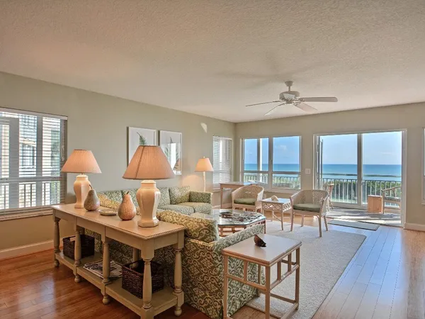 a living room with furniture a table and wooden floor