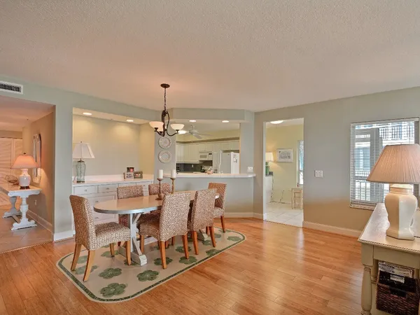 a view of a dining room with furniture a chandelier and wooden floor