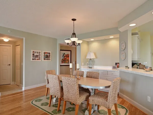 a dining room with furniture a chandelier and wooden floor