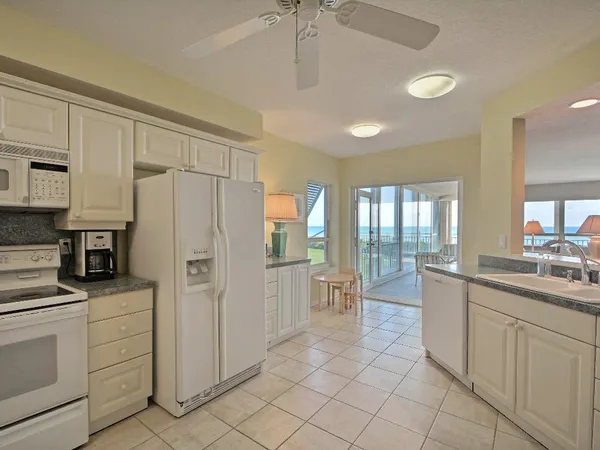 a kitchen with white cabinets and sink