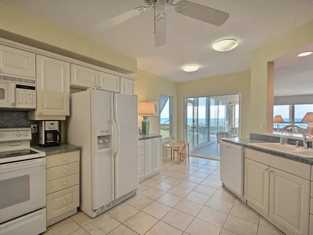a kitchen with white cabinets and sink