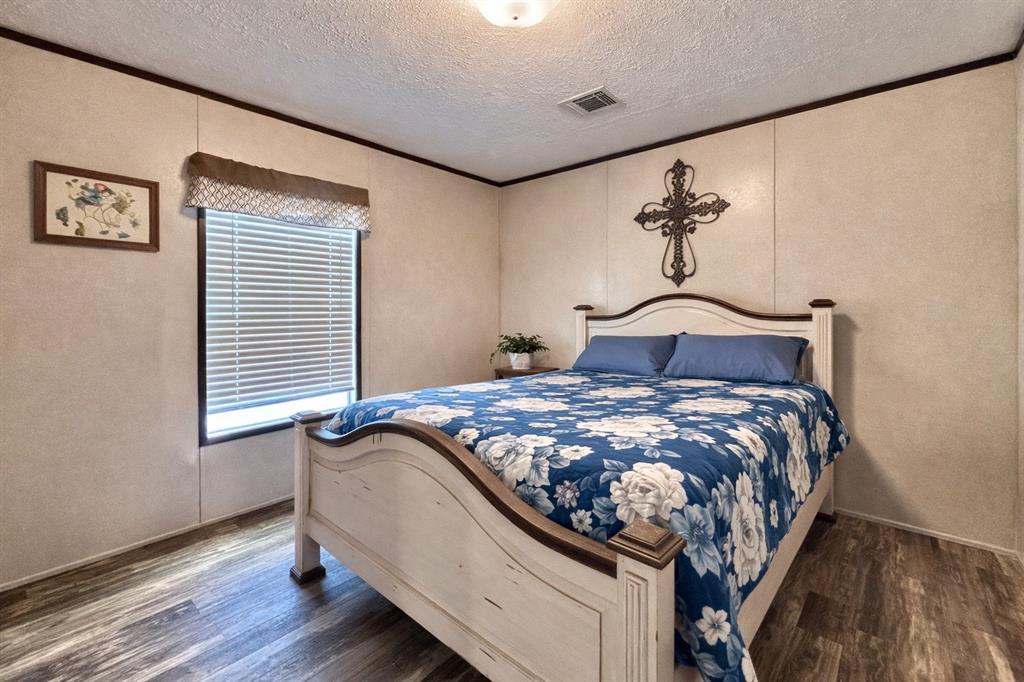 750 Waterfront Row Quitman, TX 75783 - Photo 16 of 32 a bedroom with a bed and wooden floor