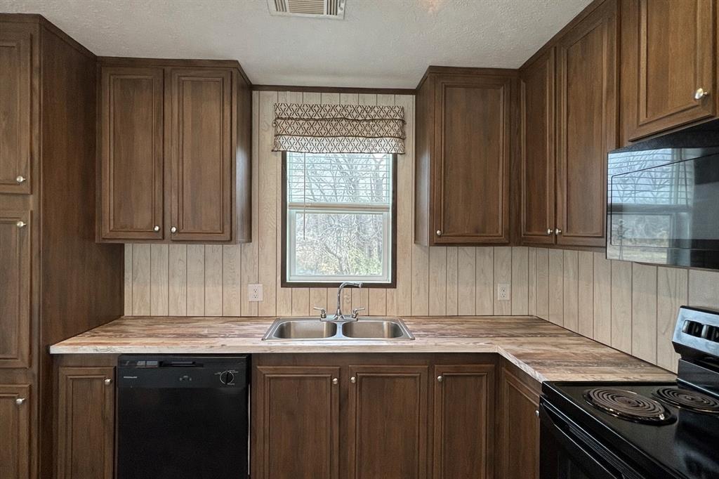 750 Waterfront Row Quitman, TX 75783 - Photo 10 of 32 a kitchen with a sink stove top oven and cabinets