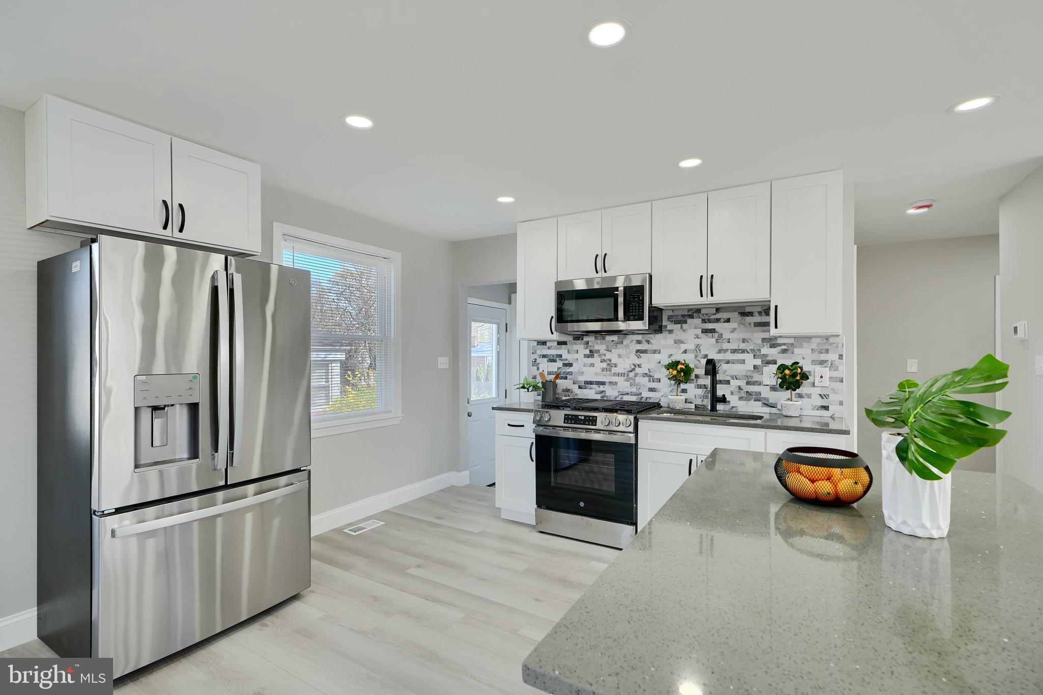 5805 Key Avenue Baltimore, MD 21215 - Photo 11 of 39 a kitchen with kitchen island granite countertop a sink a stove a refrigerator and a refrigerator