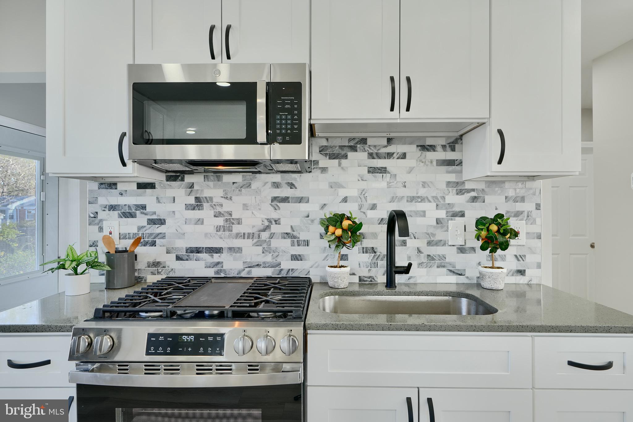 5805 Key Avenue Baltimore, MD 21215 - Photo 12 of 39 a kitchen with stainless steel appliances granite countertop a sink stove and microwave