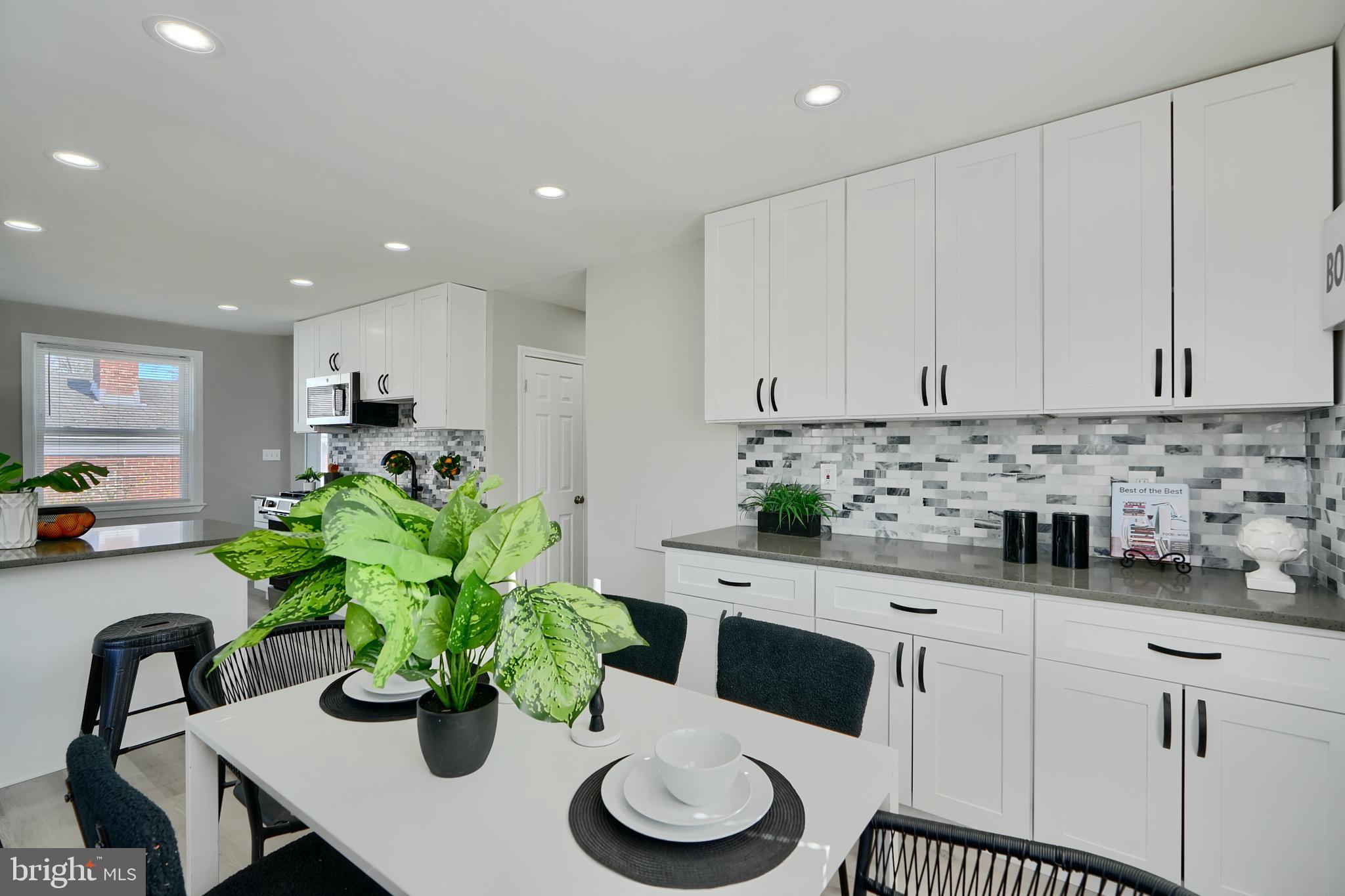 5805 Key Avenue Baltimore, MD 21215 - Photo 15 of 39 a kitchen with stainless steel appliances white cabinets a stove a sink and a potted plant