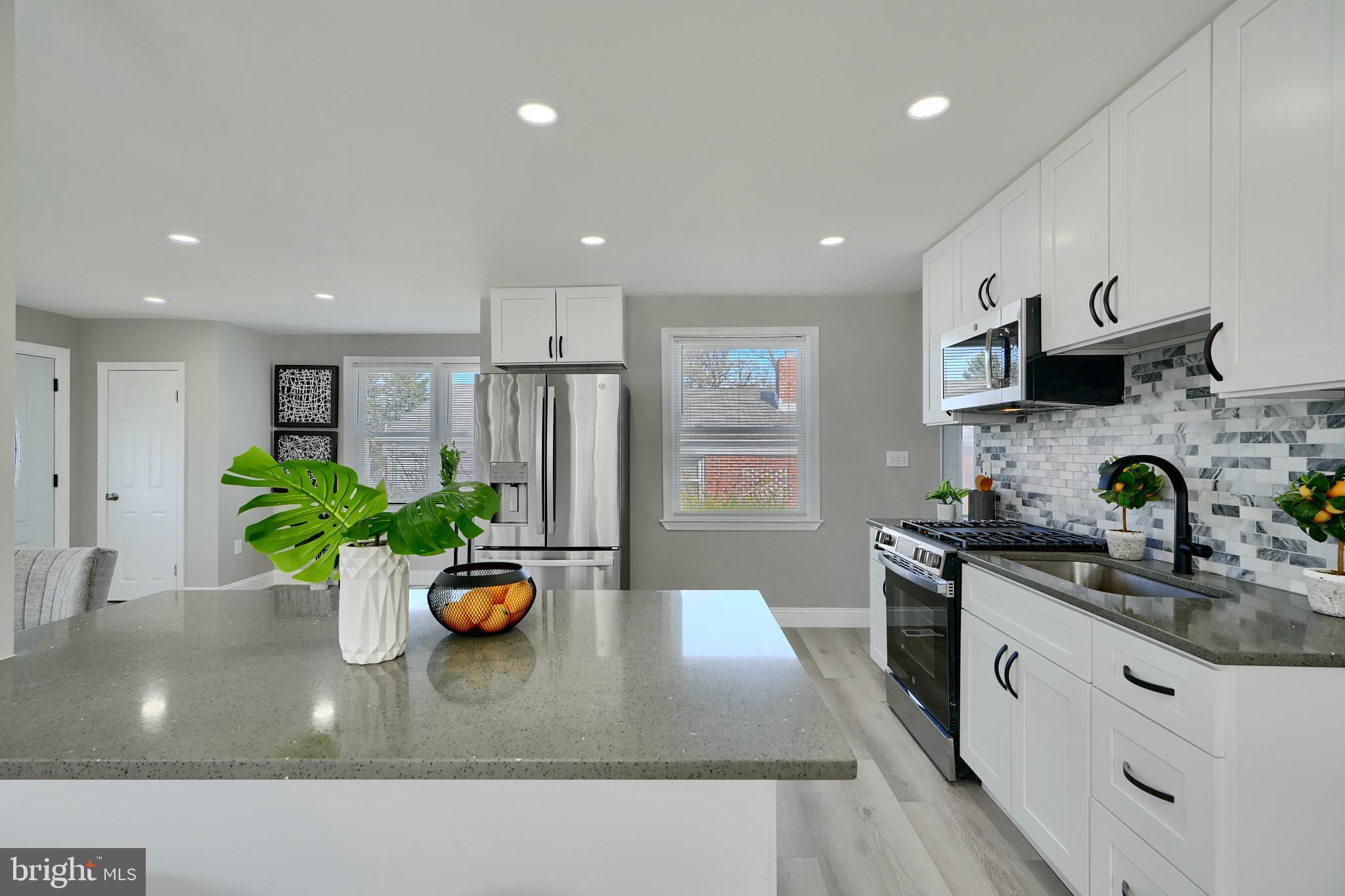 5805 Key Avenue Baltimore, MD 21215 - Photo 6 of 39 a kitchen with stainless steel appliances granite countertop a sink a stove and a wooden floors