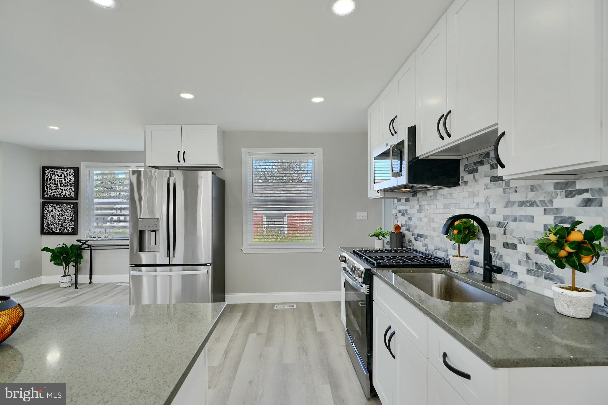 5805 Key Avenue Baltimore, MD 21215 - Photo 7 of 39 a kitchen with granite countertop a sink stainless steel appliances and cabinets