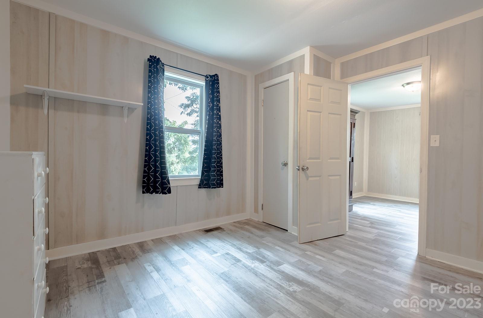 653 Sand Hill Road Asheville, NC 28806 - Photo 13 of 27 an empty room with wooden floor and windows