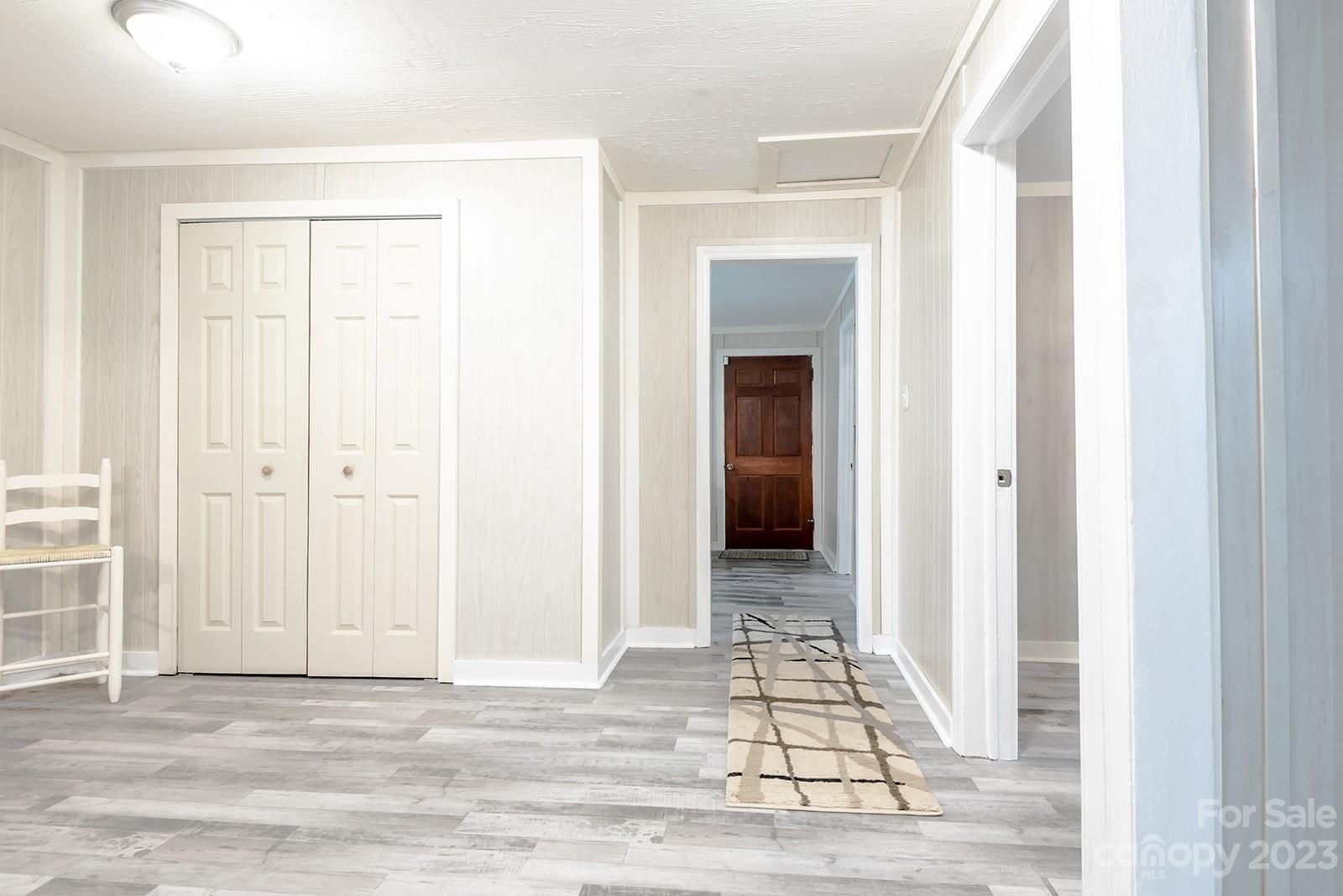 653 Sand Hill Road Asheville, NC 28806 - Photo 16 of 27 a view of a hallway with wooden floor and a living room