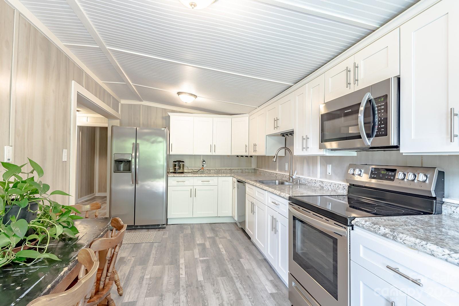 653 Sand Hill Road Asheville, NC 28806 - Photo 19 of 27 a kitchen with a sink stainless steel appliances and cabinets