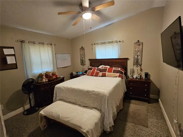 a bedroom with a bed and a flat tv screen on the dresser