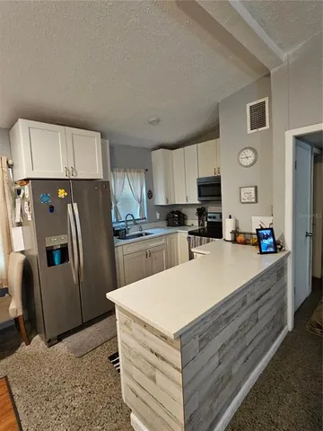 a kitchen with a refrigerator a stove top oven a sink and cabinets