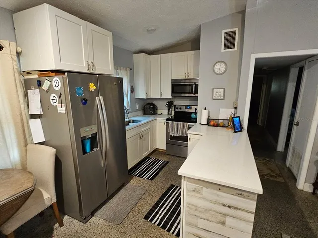 a kitchen with stainless steel appliances a refrigerator sink and microwave