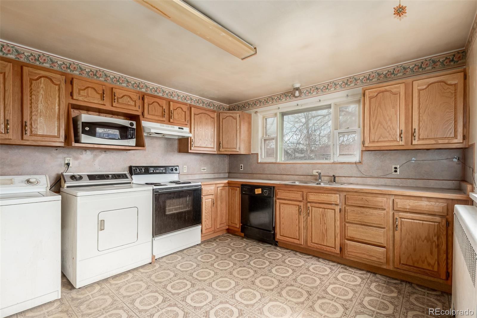 10480 West 47th Avenue Wheat Ridge, CO 80033 - Photo 12 of 29 a kitchen with stainless steel appliances granite countertop a stove top oven a sink dishwasher and white cabinets with wooden floor