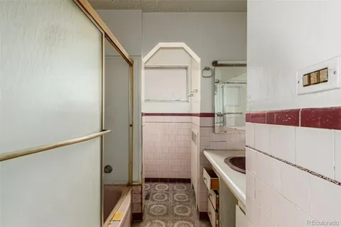 a bathroom with a glass door shower and a sink