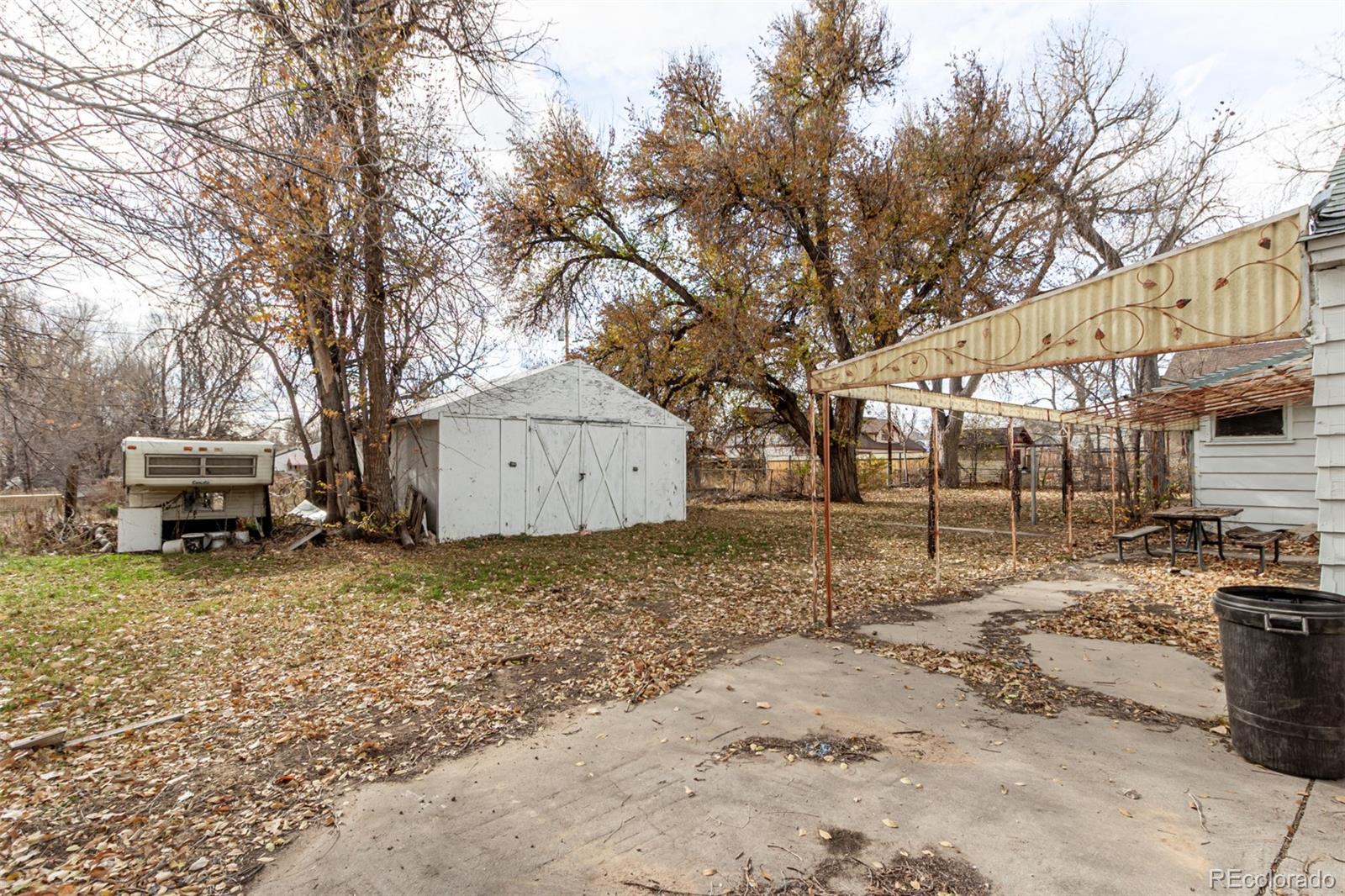 10480 West 47th Avenue Wheat Ridge, CO 80033 - Photo 24 of 29 a backyard of a house with a large tree and wooden fence